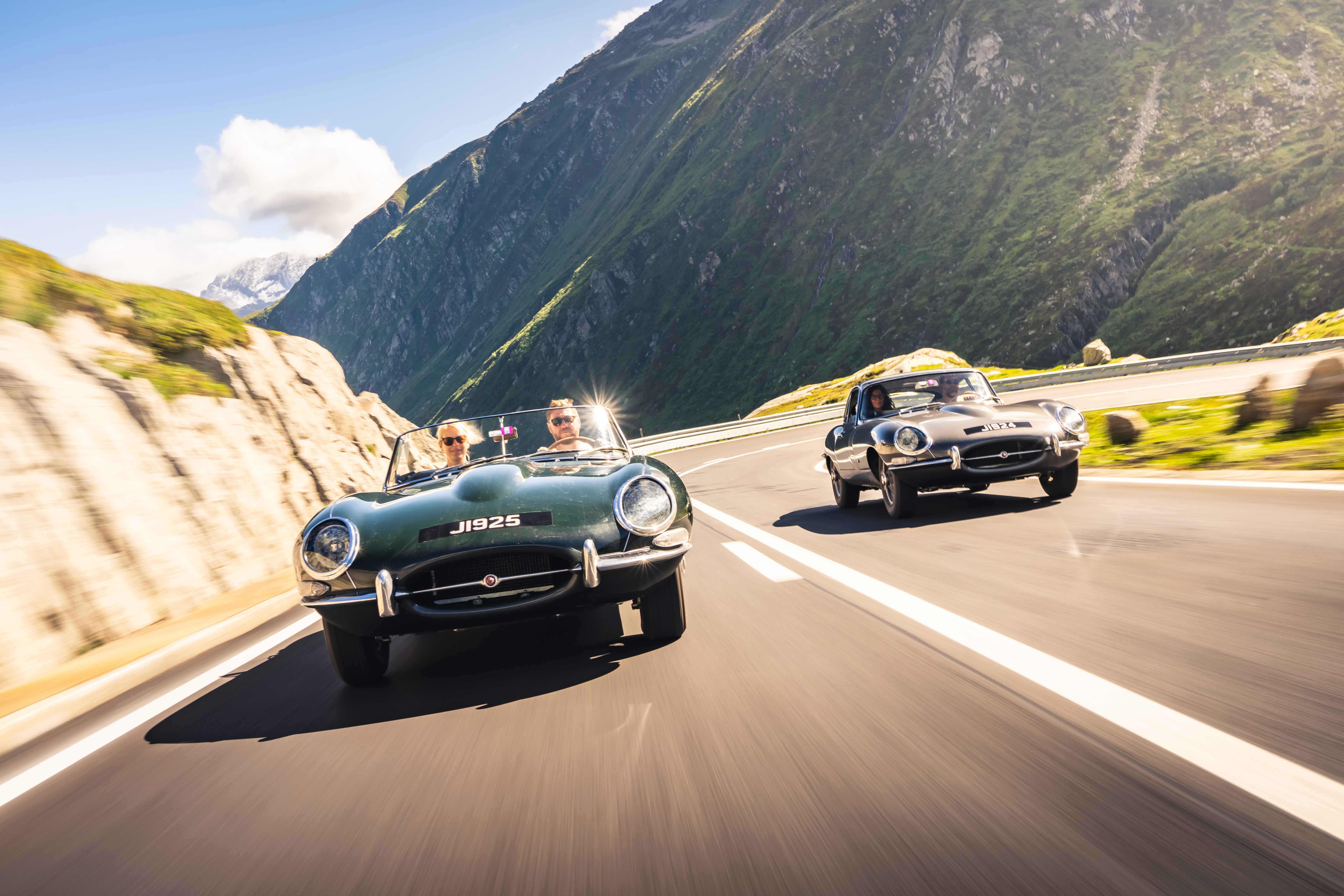 Two classic Jaguar E-Types driving through the Swiss Alps
